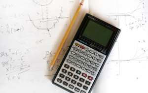 Pencil and calculator on paper with math notes