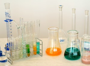 Various beakers and test tubes with colored liquids on a bench